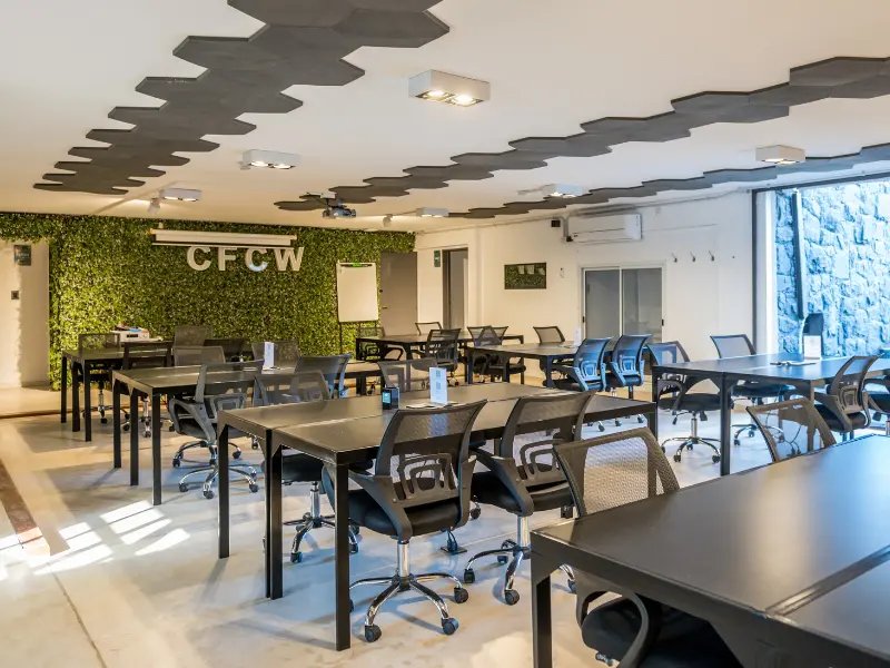 Sala de trabajo de Casa Fader Coworking con pared verde y branding CFCW